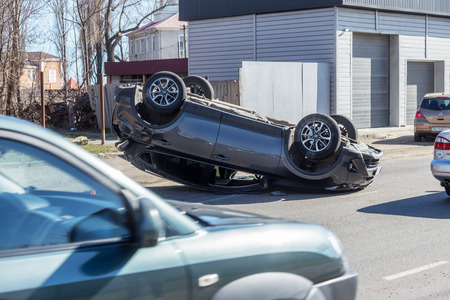 ODESSA, UKRAINE March 19, 2019: after car accident, broken car rolled over and lay down on roof on road that other cars drive. Concept of careless driving, breaking rules and speeding on roadのeditorial素材