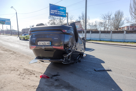 ODESSA, UKRAINE March 19, 2019: after car accident, broken car rolled over and lay down on roof on road that other cars drive. Concept of careless driving, breaking rules and speeding on roadのeditorial素材