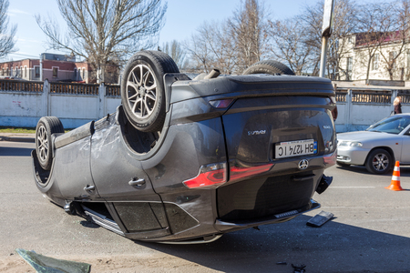 ODESSA, UKRAINE March 19, 2019: after car accident, broken car rolled over and lay down on roof on road that other cars drive. Concept of careless driving, breaking rules and speeding on roadのeditorial素材