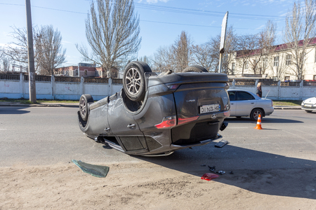 ODESSA, UKRAINE March 19, 2019: after car accident, broken car rolled over and lay down on roof on road that other cars drive. Concept of careless driving, breaking rules and speeding on roadのeditorial素材