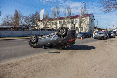 ODESSA, UKRAINE March 19, 2019: after car accident, broken car rolled over and lay down on roof on road that other cars drive. Concept of careless driving, breaking rules and speeding on roadのeditorial素材
