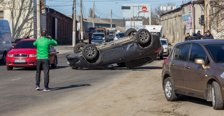 ODESSA, UKRAINE March 19, 2019: after car accident, broken car rolled over and lay down on roof on road that other cars drive. Concept of careless driving, breaking rules and speeding on roadのeditorial素材