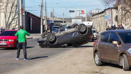 ODESSA, UKRAINE March 19, 2019: after car accident, broken car rolled over and lay down on roof on road that other cars drive. Concept of careless driving, breaking rules and speeding on roadのeditorial素材