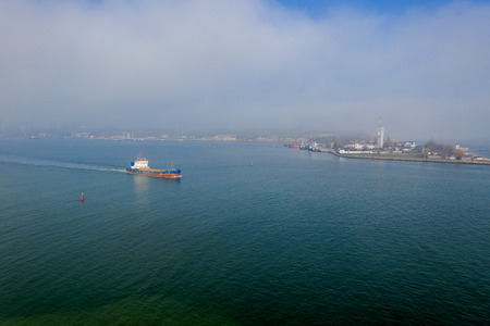 Aerial view of panoramic seaport warehouse and container ship, crane vessel working for delivery of delivery containers. Yuzhny Sea Industrial Port, Port Plant, Ukraine, 2019. Ships in sea port, fogの写真素材