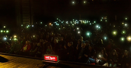 Odessa, Ukraine - April 8, 2019: crowd of spectators at rock concert by ALOSHA during music show. Crowds of happy people enjoy rock concert, raise their hands and clap their hands, spectators in standのeditorial素材