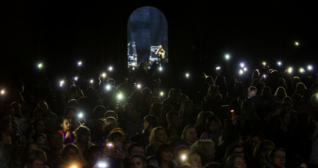 Odessa, Ukraine - April 8, 2019: crowd of spectators at rock concert by ALOSHA during music show. Crowds of happy people enjoy rock concert, raise their hands and clap their hands, spectators in standのeditorial素材