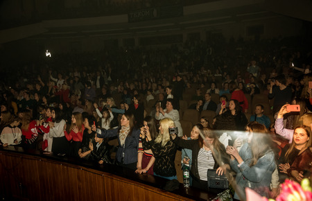Odessa, Ukraine - April 12, 2019: Crowd of spectators at rock concert ALEKSEEV during music show. Crowds of happy people enjoy rock concert, raise their hands and clap their hands, audience on podiumのeditorial素材
