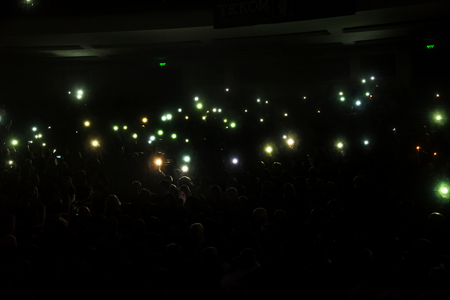 Odessa, Ukraine - April 12, 2019: Crowd of spectators at rock concert ALEKSEEV during music show. Crowds of happy people enjoy rock concert, raise their hands and clap their hands, audience on podiumのeditorial素材