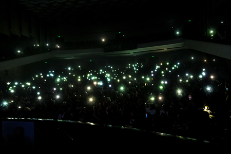 Odessa, Ukraine - April 12, 2019: Crowd of spectators at rock concert ALEKSEEV during music show. Crowds of happy people enjoy rock concert, raise their hands and clap their hands, audience on podiumのeditorial素材