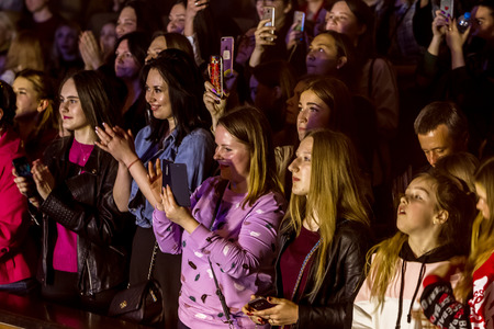 Odessa, Ukraine - April 12, 2019: Crowd of spectators at rock concert ALEKSEEV during music show. Crowds of happy people enjoy rock concert, raise their hands and clap their hands, audience on podiumのeditorial素材