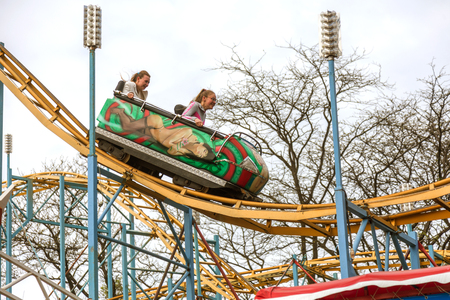 ODESSA, UKRAINE - MAY 6, 2019: Visitors ride road slides in an amusement park. Young friends on an exciting rollercoaster. Young people having fun in an amusement park. Scary fun on roller coasterのeditorial素材