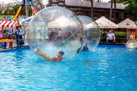 Odessa, Ukraine - May 6, 2019. Little children in an inflatable balloon, having fun on the water. The ball in the water - fascinating summer attractions for children. Water zorbingのeditorial素材
