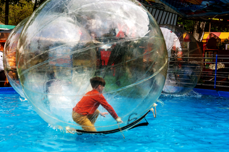 Odessa, Ukraine - May 6, 2019. Little children in an inflatable balloon, having fun on the water. The ball in the water - fascinating summer attractions for children. Water zorbingのeditorial素材