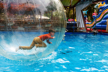 Odessa, Ukraine - May 6, 2019. Little children in an inflatable balloon, having fun on the water. The ball in the water - fascinating summer attractions for children. Water zorbingのeditorial素材