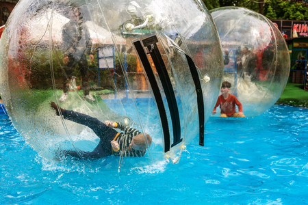 Odessa, Ukraine - May 6, 2019. Little children in an inflatable balloon, having fun on the water. The ball in the water - fascinating summer attractions for children. Water zorbingのeditorial素材