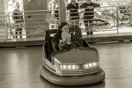 Odessa, Ukraine - June 13, 2016: A group of happy parents, boys and girls having fun and joy ride in bumper car on fairground rides at an amusement park. City bumper car park entertainmentのeditorial素材
