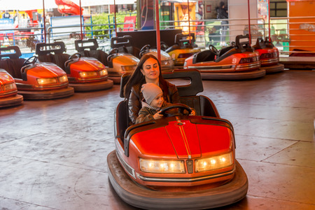 Odessa, Ukraine - June 13, 2016: A group of happy parents, boys and girls having fun and joy ride in bumper car on fairground rides at an amusement park. City bumper car park entertainmentのeditorial素材
