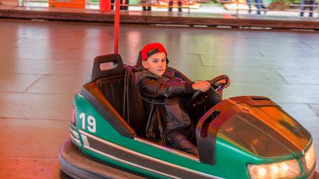 Odessa, Ukraine - June 13, 2016: A group of happy parents, boys and girls having fun and joy ride in bumper car on fairground rides at an amusement park. City bumper car park entertainmentのeditorial素材