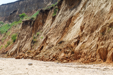 Landslide zone on Black Sea coast. Rock of sea rock shell. Zone of natural disasters during rainy season. Large masses of earth slip along slope of hill, destroy houses. Landslide - threat to lifeの写真素材