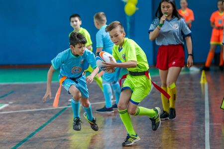 ODESSA, UKRAINE - MAY 18, 2019: Young children play rugby during final games of championship in hall. Children's sport. Children play rugby 5. Fight for victory of children in rugbyのeditorial素材
