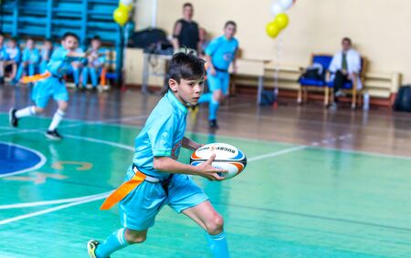 ODESSA, UKRAINE - MAY 18, 2019: Young children play rugby during final games of championship in hall. Children's sport. Children play rugby 5. Fight for victory of children in rugbyのeditorial素材