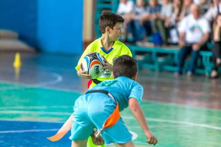 ODESSA, UKRAINE - MAY 18, 2019: Young children play rugby during final games of championship in hall. Children's sport. Children play rugby 5. Fight for victory of children in rugbyのeditorial素材