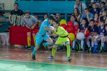 ODESSA, UKRAINE - MAY 18, 2019: Young children play rugby during final games of championship in hall. Children's sport. Children play rugby 5. Fight for victory of children in rugbyのeditorial素材