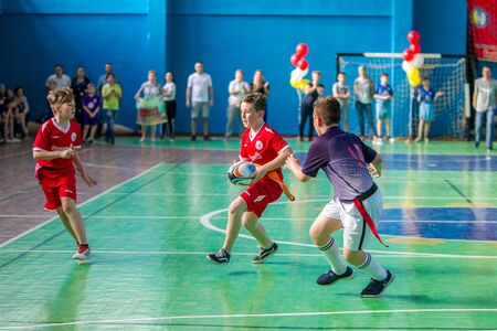 ODESSA, UKRAINE - MAY 18, 2019: Young children play rugby during final games of championship in hall. Children's sport. Children play rugby 5. Fight for victory of children in rugbyのeditorial素材