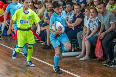 ODESSA, UKRAINE - MAY 18, 2019: Young children play rugby during final games of championship in hall. Children's sport. Children play rugby 5. Fight for victory of children in rugbyのeditorial素材