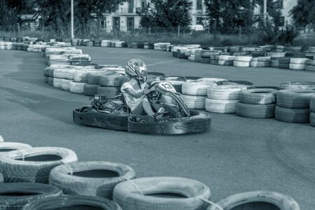 ODESSA, UKRAINE - June 19, 2019: karting. Racers on races on special safe high-speed tracks limited by car tires. Attraction High-speed ride in carts. Sport karting entertainmentのeditorial素材