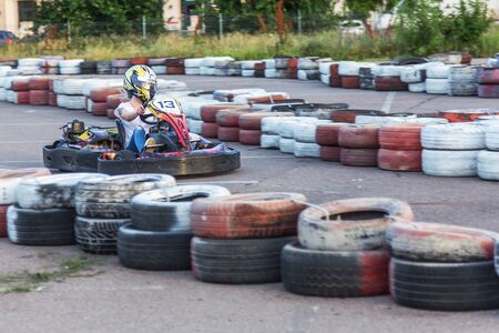 ODESSA, UKRAINE - June 19, 2019: karting. Racers on races on special safe high-speed tracks limited by car tires. Attraction High-speed ride in carts. Sport karting entertainmentのeditorial素材