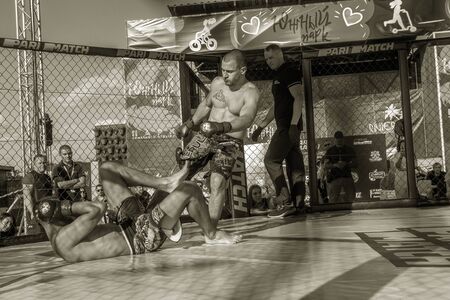 ODESSA, UKRAINE-June 30, 2019: Fighters of MMA boxers are fighting without rules in cage ring of octagons. MMA fighters in ring at  championship. Look at boxing fights without rules through metal cageのeditorial素材