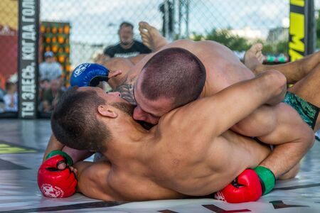 ODESSA, UKRAINE-June 30, 2019: Fighters of MMA boxers are fighting without rules in cage ring of octagons. MMA fighters in ring at  championship. Look at boxing fights without rules through metal cageのeditorial素材