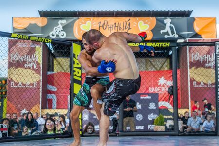 ODESSA, UKRAINE-June 30, 2019: Fighters of MMA boxers are fighting without rules in cage ring of octagons. MMA fighters in ring at  championship. Look at boxing fights without rules through metal cageのeditorial素材