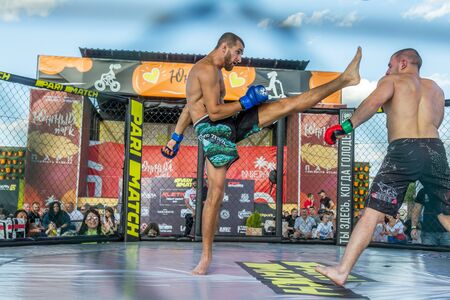 ODESSA, UKRAINE-June 30, 2019: Fighters of MMA boxers are fighting without rules in cage ring of octagons. MMA fighters in ring at  championship. Look at boxing fights without rules through metal cageのeditorial素材