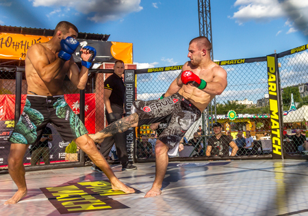 ODESSA, UKRAINE-June 30, 2019: Fighters of MMA boxers are fighting without rules in cage ring of octagons. MMA fighters in ring at  championship. Look at boxing fights without rules through metal cageのeditorial素材