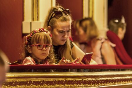 Odessa, Ukraine - CIRCA 2019: selective focus. Spectators children in theater during popular children's play. Children's Delight audience. Concert audience in motion. Children's spectators in theaterのeditorial素材