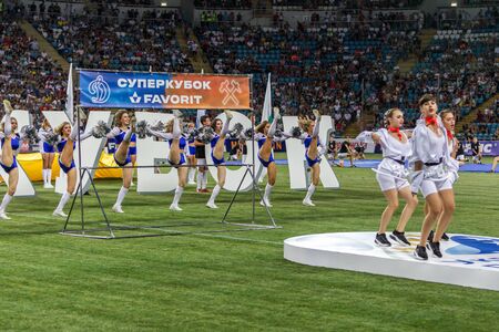 ODESSA, UKRAINE - July28, 2019: Performance of beautiful young girls cheerleader team during opening of football championship. Team performance cheerleader on grass field stadium. Girls of cheerleaderのeditorial素材
