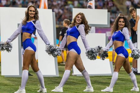 ODESSA, UKRAINE - July28, 2019: Performance of beautiful young girls cheerleader team during opening of football championship. Team performance cheerleader on grass field stadium. Girls of cheerleaderのeditorial素材