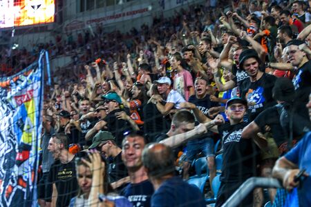 Out of focus, not sharp sport background - spectators at stadium. Crowds of fans in stands of...
