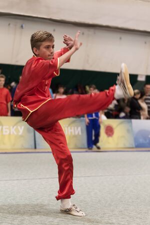 ODESSA, UKRAINE - October 1, 2019: Wushu athlete during the Wushu competition among children. Young athletes in competitions perform Chinese martial arts called Shaolin Kung Fu (Shaolin Wushu)のeditorial素材