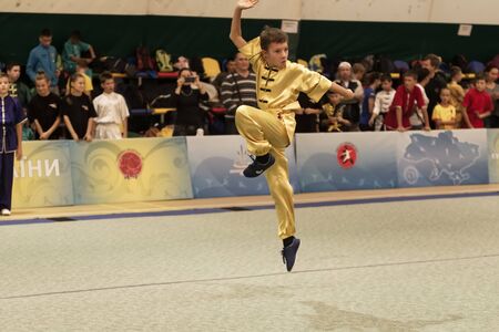 ODESSA, UKRAINE - October 1, 2019: Wushu athlete during the Wushu competition among children. Young athletes in competitions perform Chinese martial arts called Shaolin Kung Fu (Shaolin Wushu)のeditorial素材
