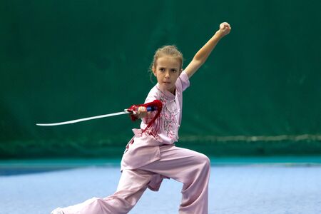 ODESSA, UKRAINE - October 1, 2019: Wushu athlete during the Wushu competition among children. Young athletes in competitions perform Chinese martial arts called Shaolin Kung Fu (Shaolin Wushu)のeditorial素材