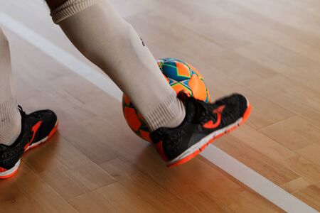 Odessa, Ukraine - October 6, 2019: Unidentified local team players play indoor soccer futsal tournament on the parquet floor. The right moment of a sports soccer game in an indoor hall, indoor soccerのeditorial素材