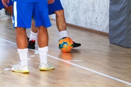 Odessa, Ukraine - October 6, 2019: Unidentified local team players play indoor soccer futsal tournament on the parquet floor. The right moment of a sports soccer game in an indoor hall, indoor soccerのeditorial素材