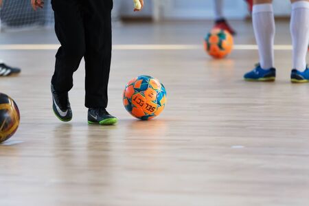 Odessa, Ukraine - October 6, 2019: Unidentified local team players play indoor soccer futsal tournament on the parquet floor. The right moment of a sports soccer game in an indoor hall, indoor soccerのeditorial素材