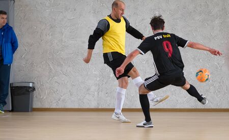 Odessa, Ukraine - October 6, 2019: Unidentified local team players play indoor soccer futsal tournament on the parquet floor. The right moment of a sports soccer game in an indoor hall, indoor soccerのeditorial素材