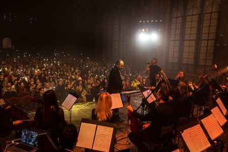 Odessa, Ukraine-circa 2019: Dark background Bright lights music show.  Rock concert and Symphony orchestra.  Conductor, musical instrument on concert stage of theater. Orchestral instruments on stageのeditorial素材