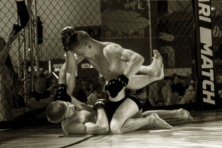 ODESSA, UKRAINE-June 30, 2019: Fighters of MMA boxers are fighting without rules in cage ring of octagons. MMA fighters in ring at championship. Look at boxing fights without rules through metal cageのeditorial素材