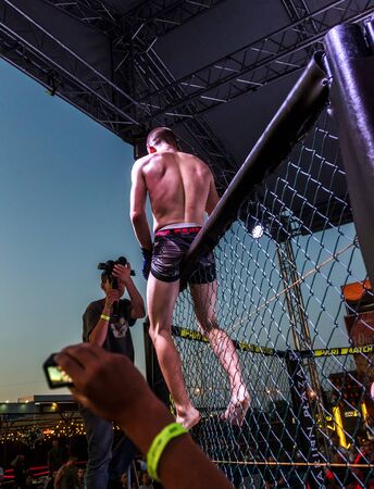 ODESSA, UKRAINE-June 30, 2019: Fighters of MMA boxers are fighting without rules in cage ring of octagons. MMA fighters in ring at championship. Look at boxing fights without rules through metal cageのeditorial素材